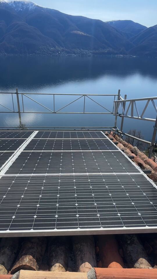 Neu verlegte Solarmodule vor Gerüst, See und Bergen