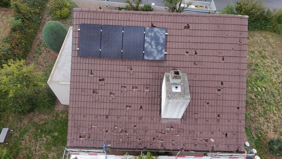 Vorher: Ziegeldach mit Hagelschaden aus der Luft, gebrochene Ziegel, zerschlagenes Solarmodul